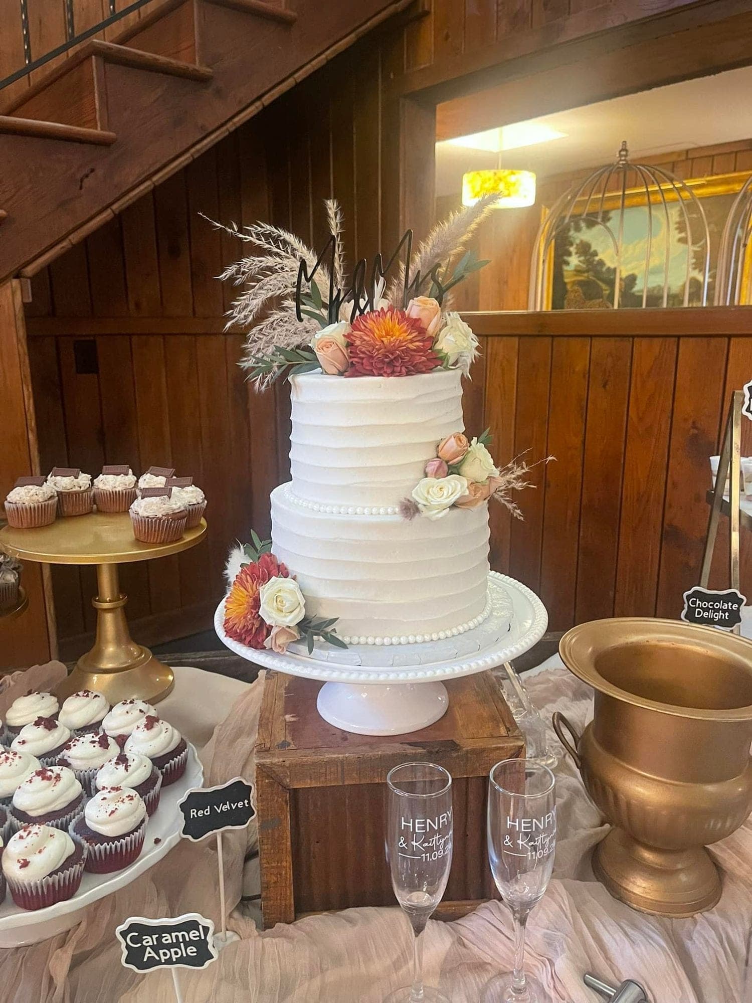 Ruffled wedding cake with cupcakes and gold urns